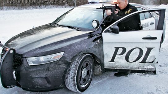 Lt. Ron Wright, armed with a Bushmaster M4, takes cover behind a Ford Taurus Police Interceptor during a felony stop.