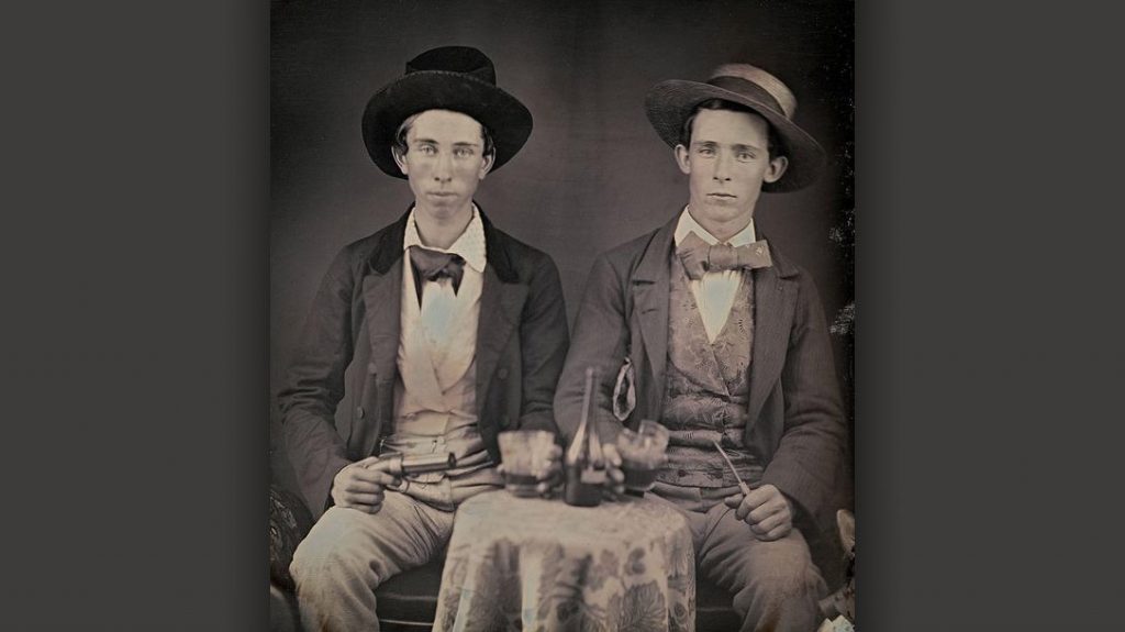 Two young men pose with a pepperbox.