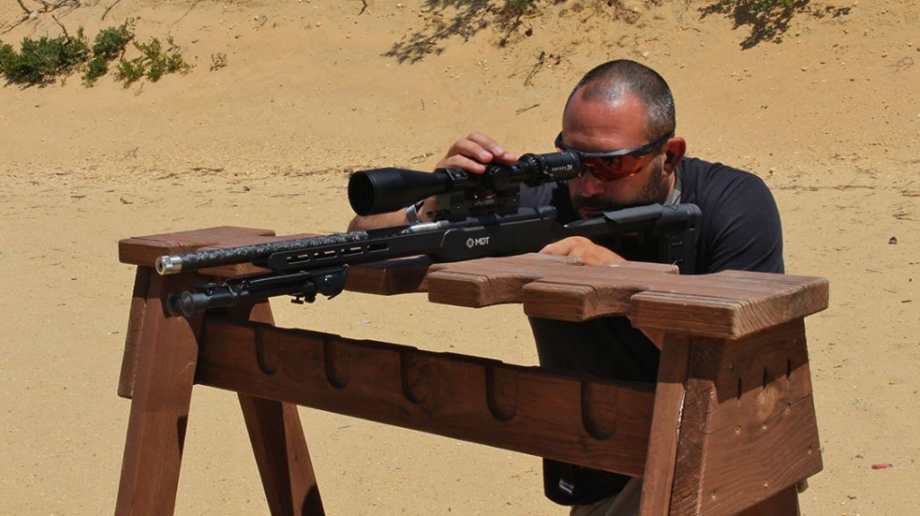 The author fires the Savage B22 Precision Lite from a rifle rack.
