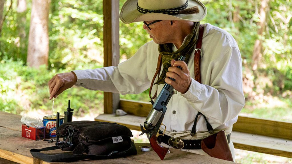 Loading a cap-and-ball revolver can be a chore. Loose black powder and a ball are rammed in, and then vegetable shortening is used to seal each chamber mouth.