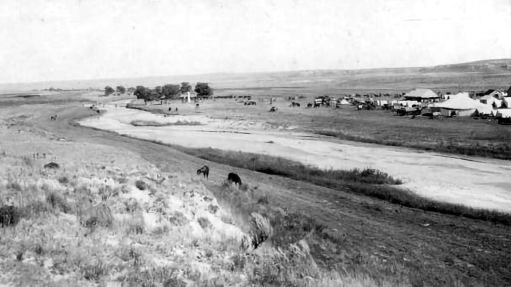 Photograph of Beecher Island as it appeared in 1917 with an early monument in place. A flood in the 1930s washed away the monument and the island. The site can still be visited today, but the topography of the riverbed has changed.